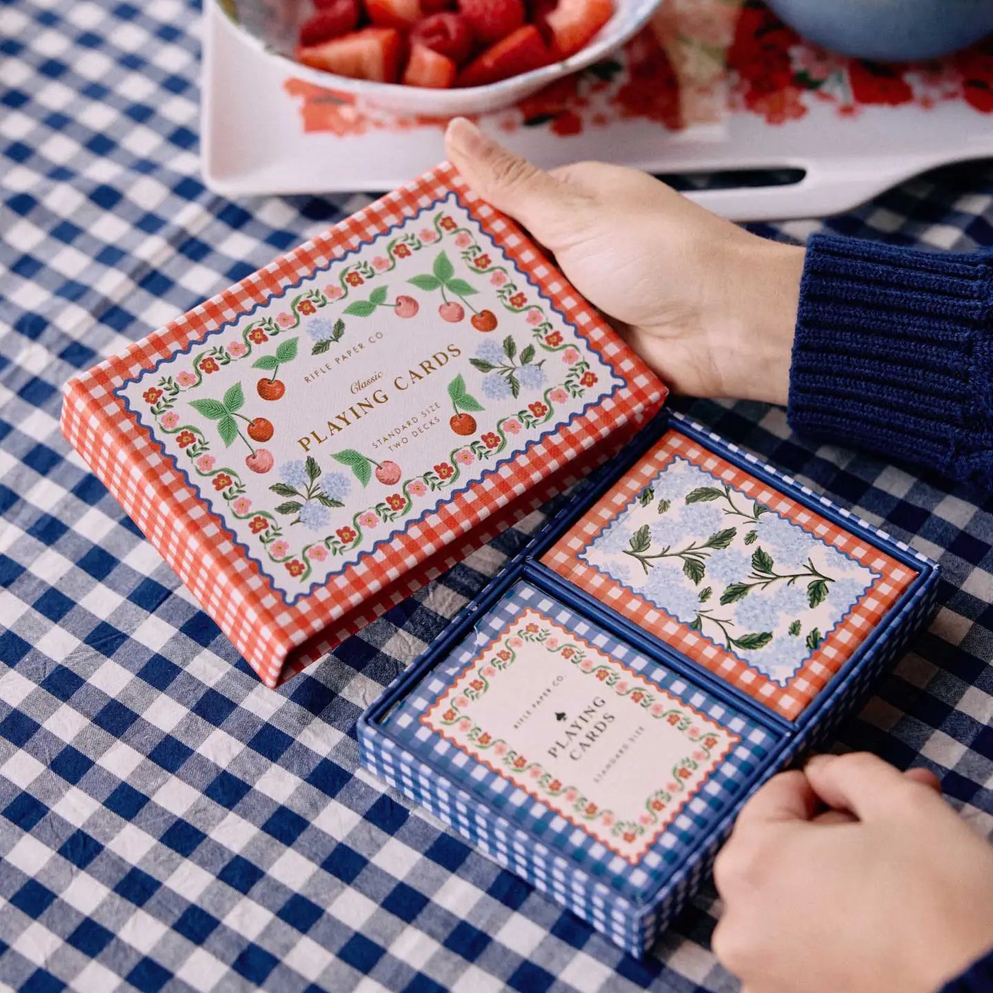 rifle paper co picnic playing cards on a blue gingham tablecloth