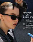 A woman wearing black sunglasses holds a black mascara wand above her hair while another hand holds a blue lip product. Text on the right reads 'MASTER YOUR SLICK BACK' with bullet points about the brush applicator and silicone-free formula.