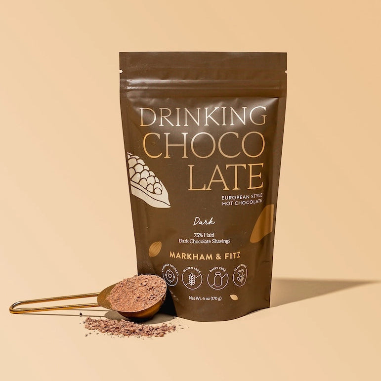 Packaging of Drinking Chocolate with a spoonful of powder on a beige background