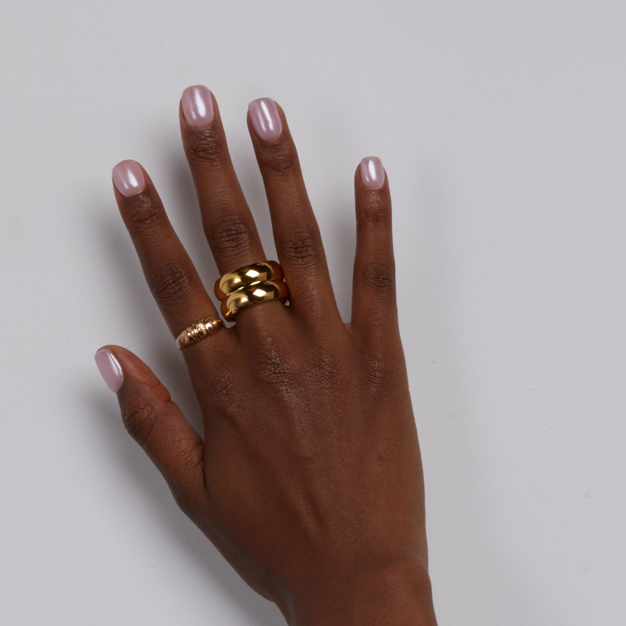 Hand wearing chunky gold rings