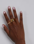 Hand wearing chunky gold rings