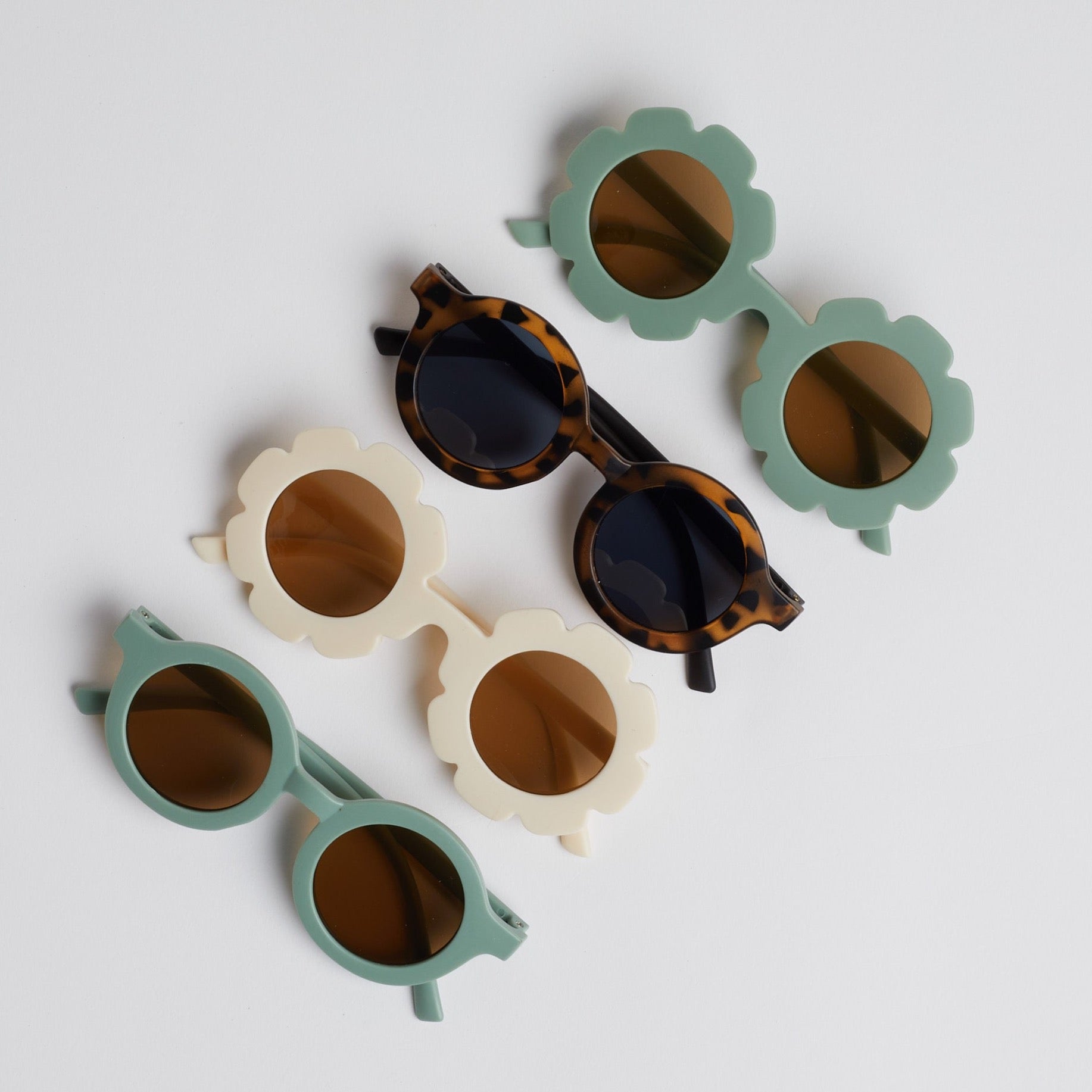 Line of baby sunglasses on white