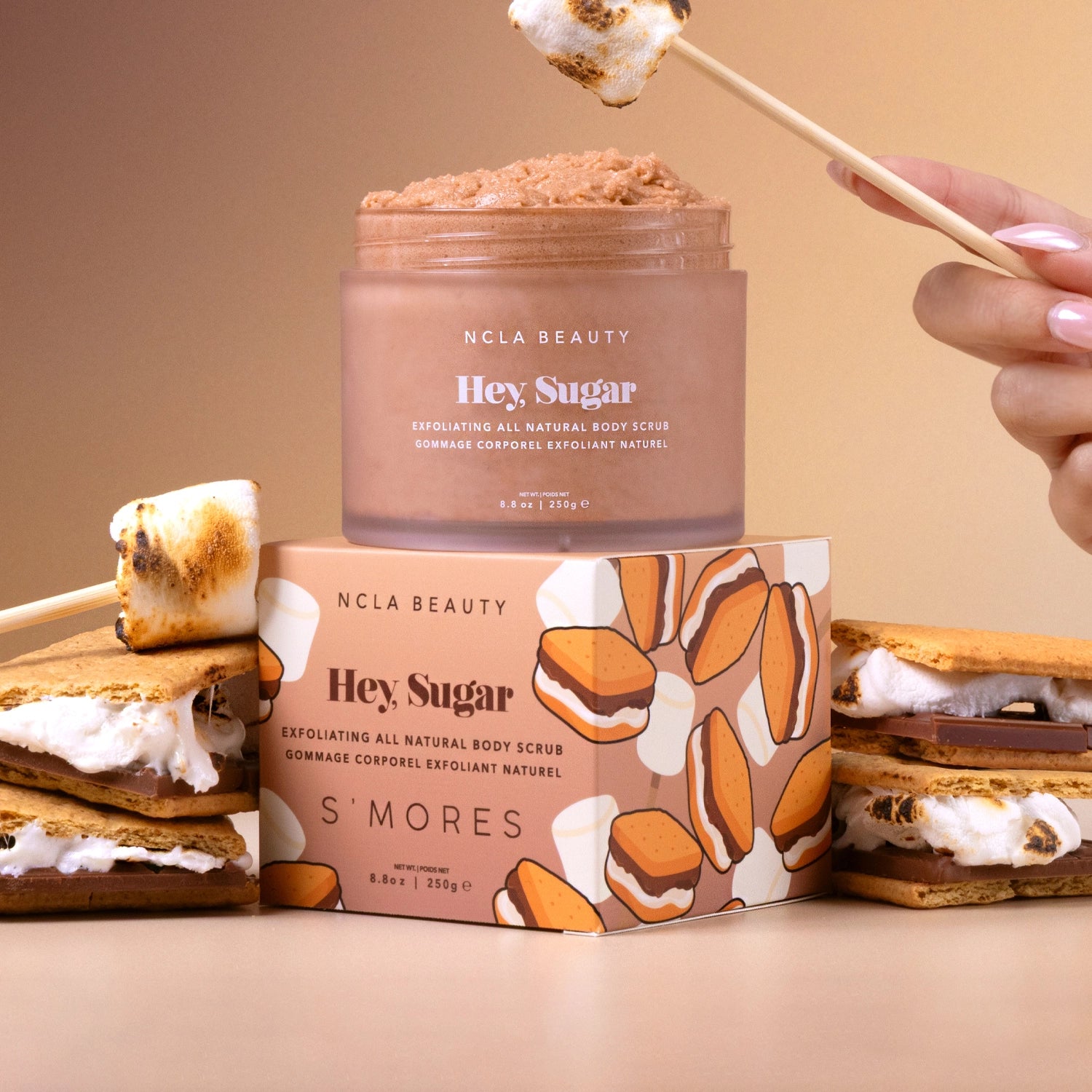 NCLA Beauty 'Hey Sugar' S'mores themed body scrub with packaging and marshmallows on a beige background