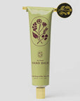 Green hand balm tube with floral design on a light gray background