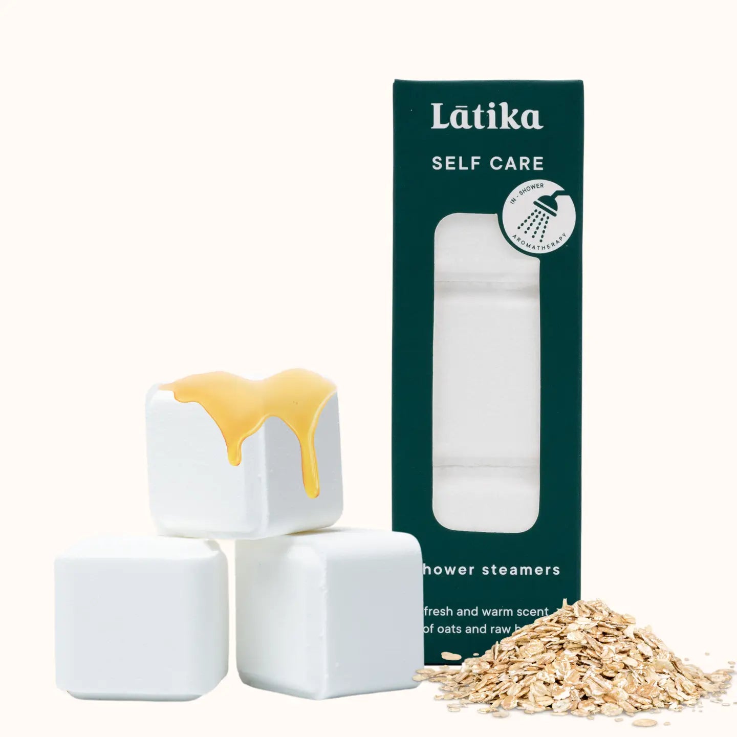 White shower steamers with a yellow top, green packaging labeled 'Latika Self Care', and oats on a white background.