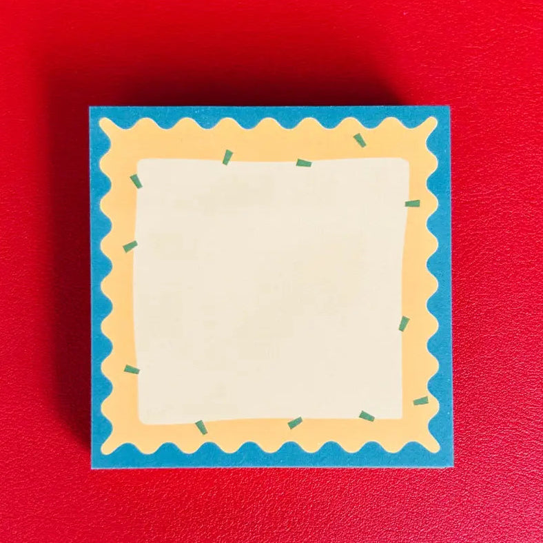 Small notepad with decorative blue border on a red background