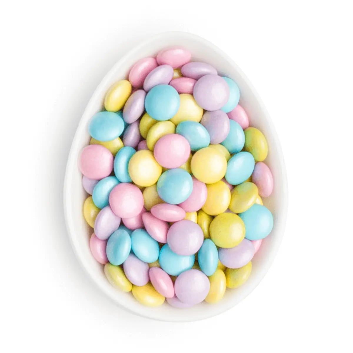 Pastel colored candies in a white bowl on a white background