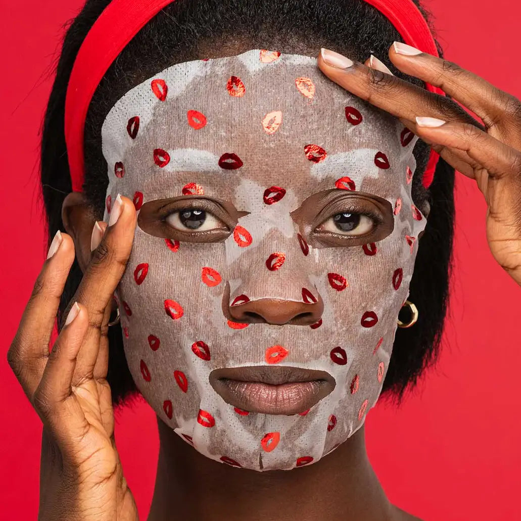 Person wearing a face mask with red lip prints against a red background