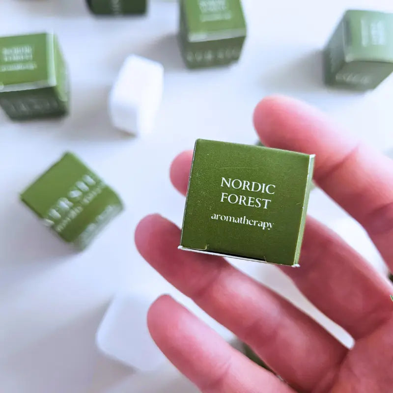 hand holding a green box that says nordic forest aromatherapy 