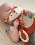 Baby holding a soft toy with a neutral background