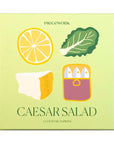 Pack of cocktail napkins with Caesar salad ingredients on a light green background