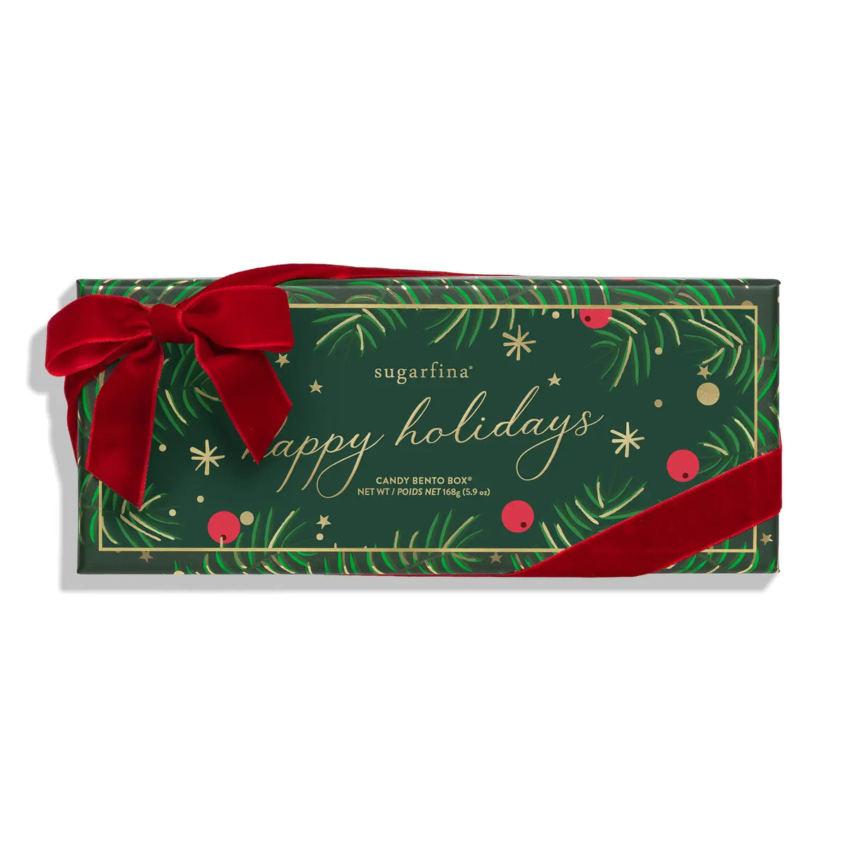 A Sugarfina holiday candy Bento box in dark green wrapping paper decorated with gold foil pine branches, red berries, and a large red velvet bow, on a white background.