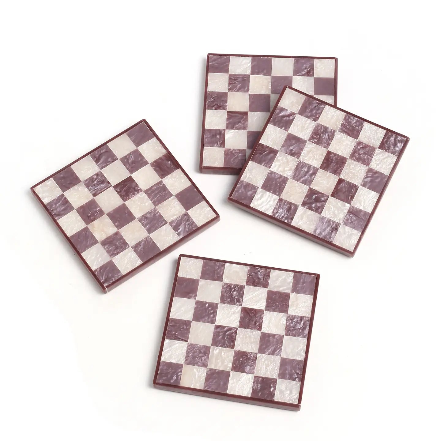 Four checkered coasters with a maroon and white pattern on a white background