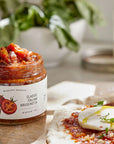 Jar of McEvoy Ranch Classic Italian Bruschetta spread on a wooden surface with a blurred background.