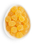 White bowl filled with yellow gummy candies on a white background