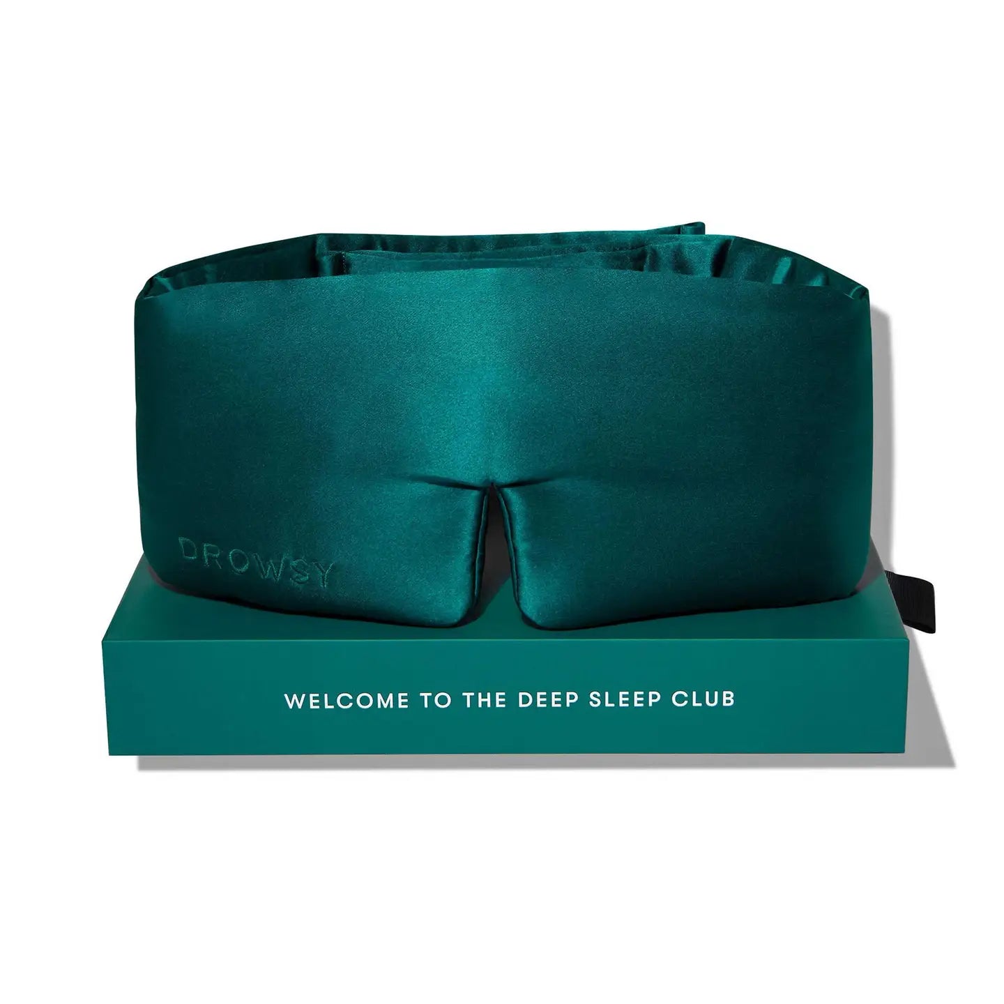 Teal sleep mask on a matching box with 'Drowzy' branding and text.