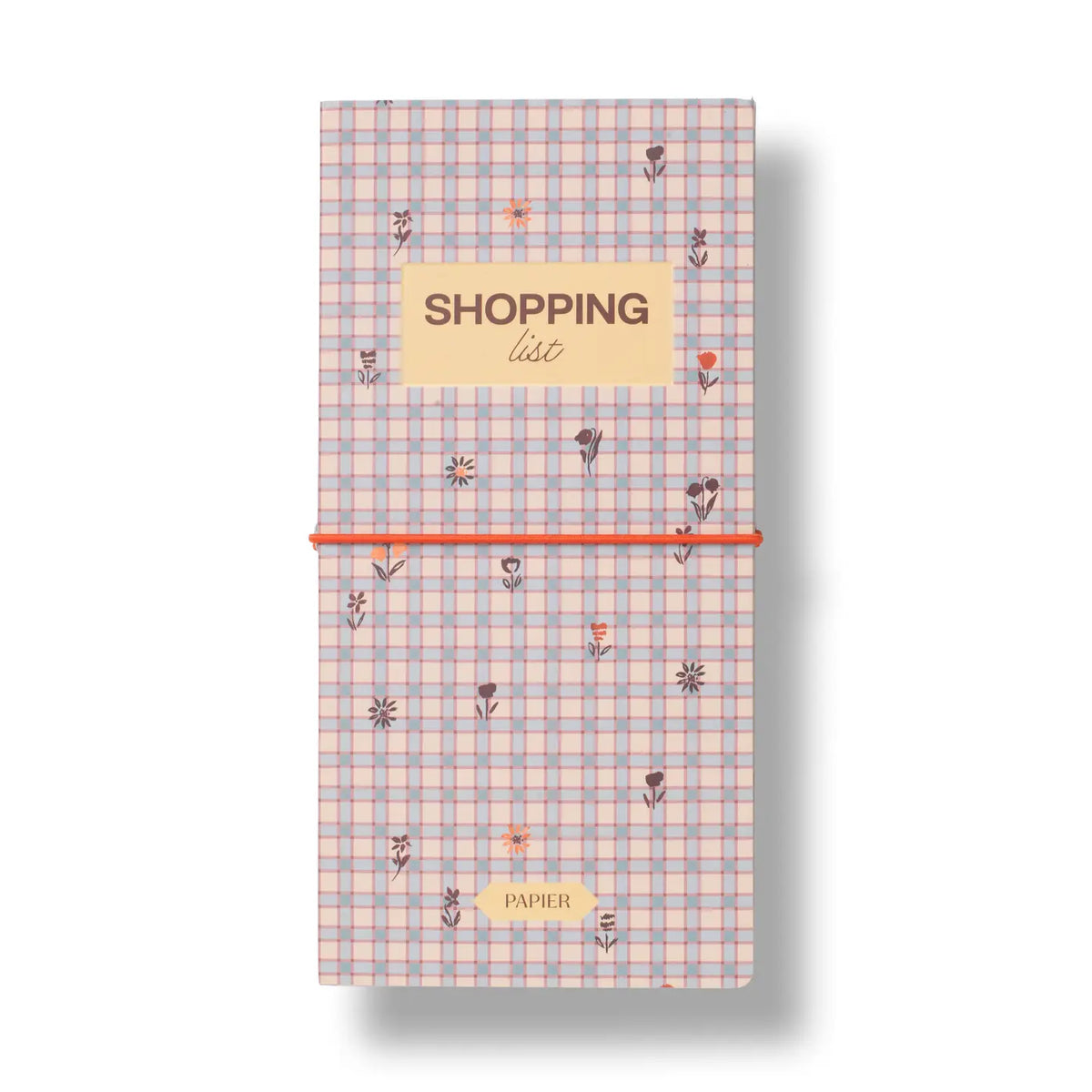 A long, narrow shopping list notebook with a pastel pink and blue gingham pattern, decorated with small floral illustrations. It features a beige label at the top reading 'SHOPPING list' and a bright orange elastic closure band across the middle, set against a plain white background with a soft drop shadow.
