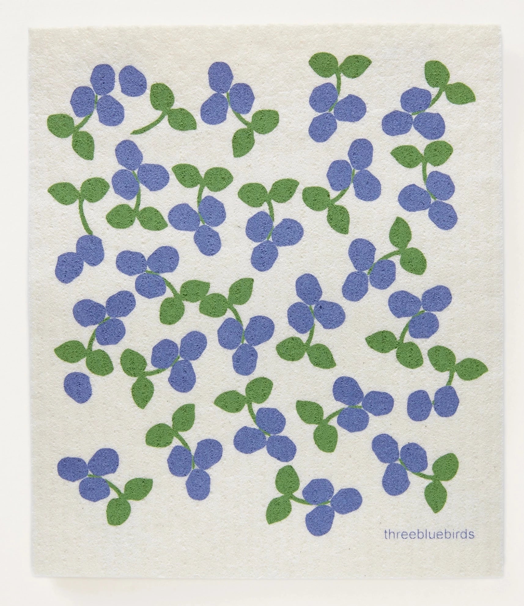 Swedish dish cloth with blue berries printed on it . blueberries have green leaves