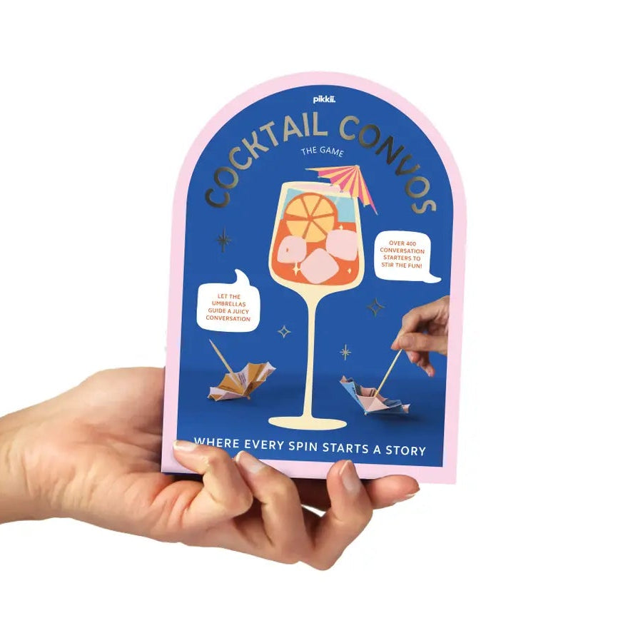 Hand holding a product packaging with cocktail-themed design on a white background