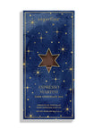 A single packaged chocolate bar package standing upright on a white background. The front is dark navy blue with a gold border, scattered gold stars, and a large central gold star containing a brown chocolate window.
