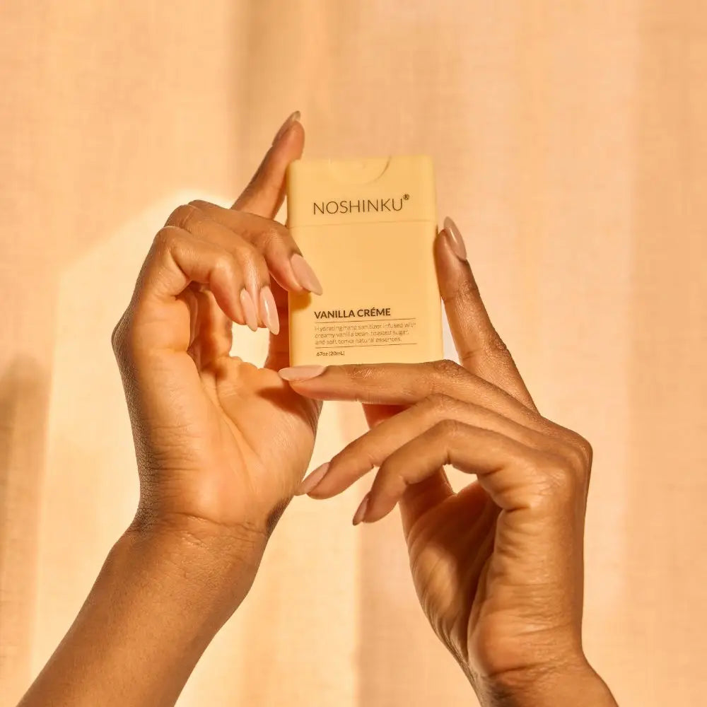 Hands holding a Noshinku Vanilla Creme product against a beige background