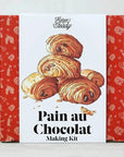 A boxed baking kit labeled 'Farm Steady' and 'Pain au Chocolat Making Kit,' with illustrated chocolate croissants on the front and red patterned side panels.