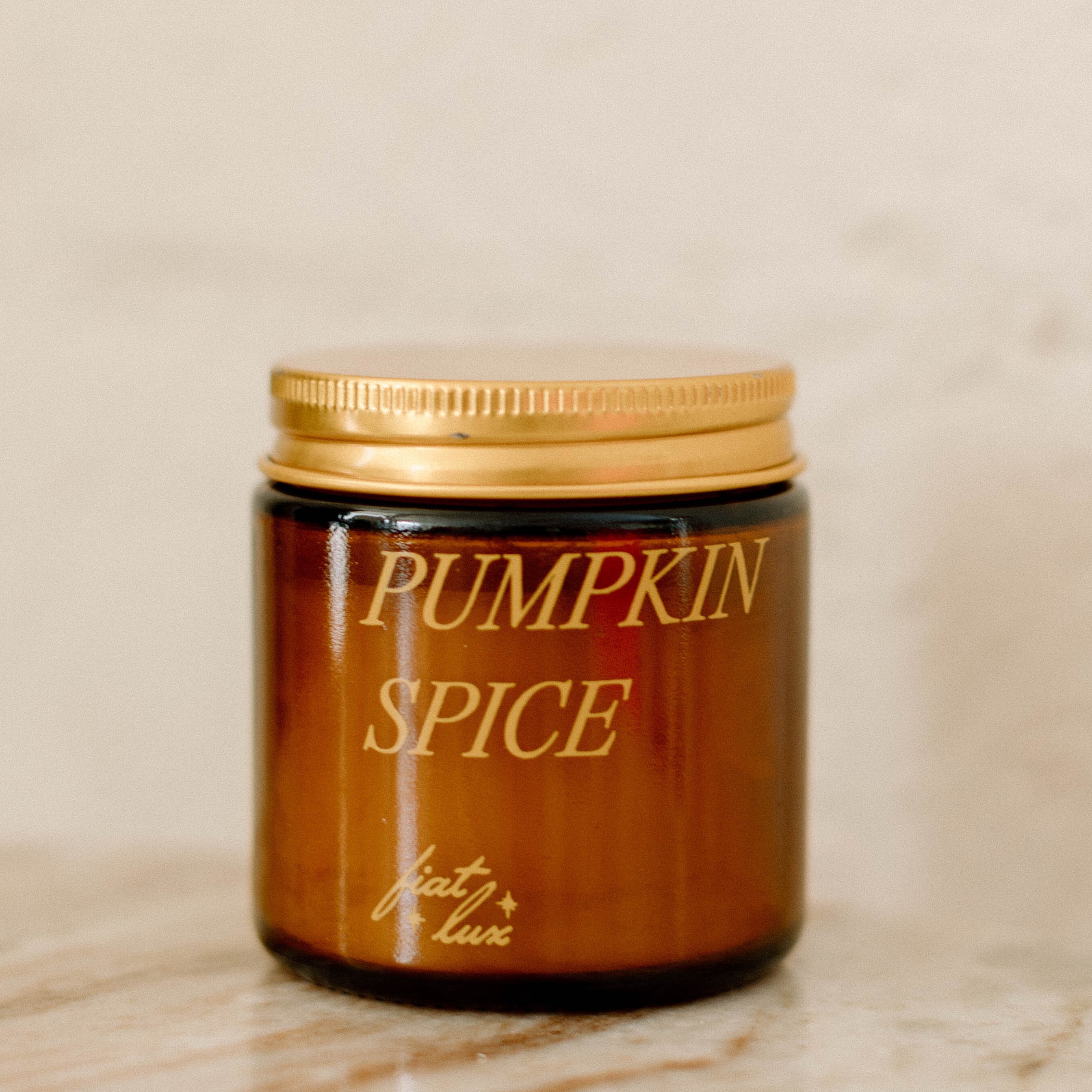 mini amber candle jar with &#39;PUMPKIN SPICE&#39; printed on it