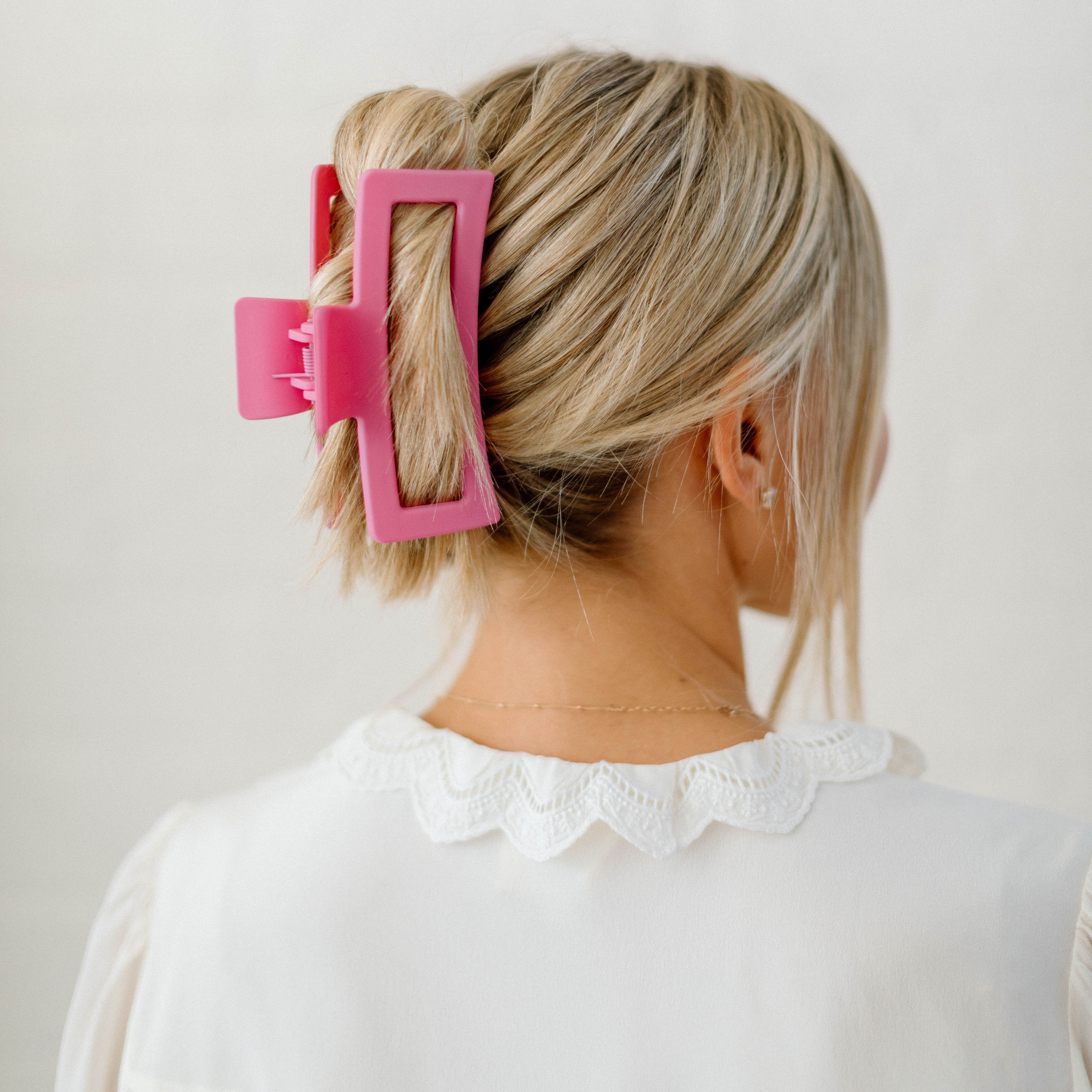 large pink clip in blonde hair