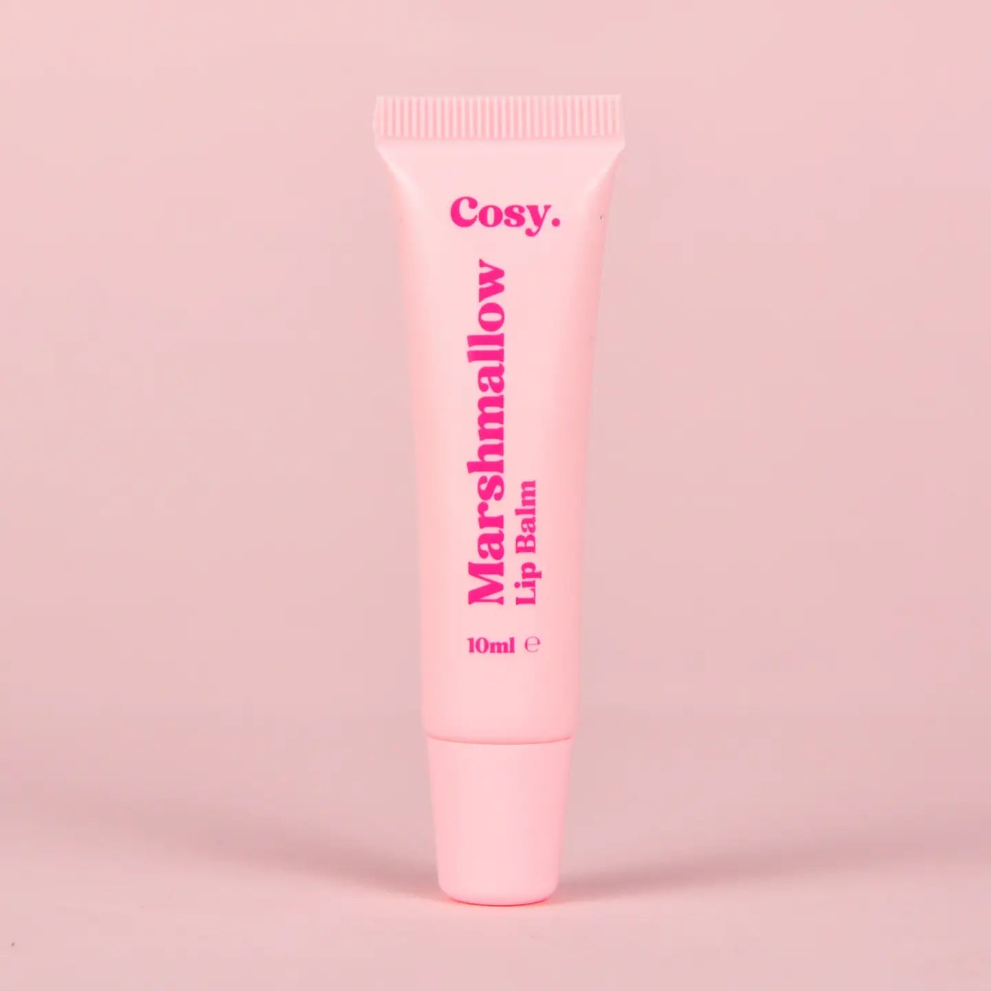 Pink lip balm tube labeled 'Marshmallow Lip Balm' by 'Cosy.' on a pink background