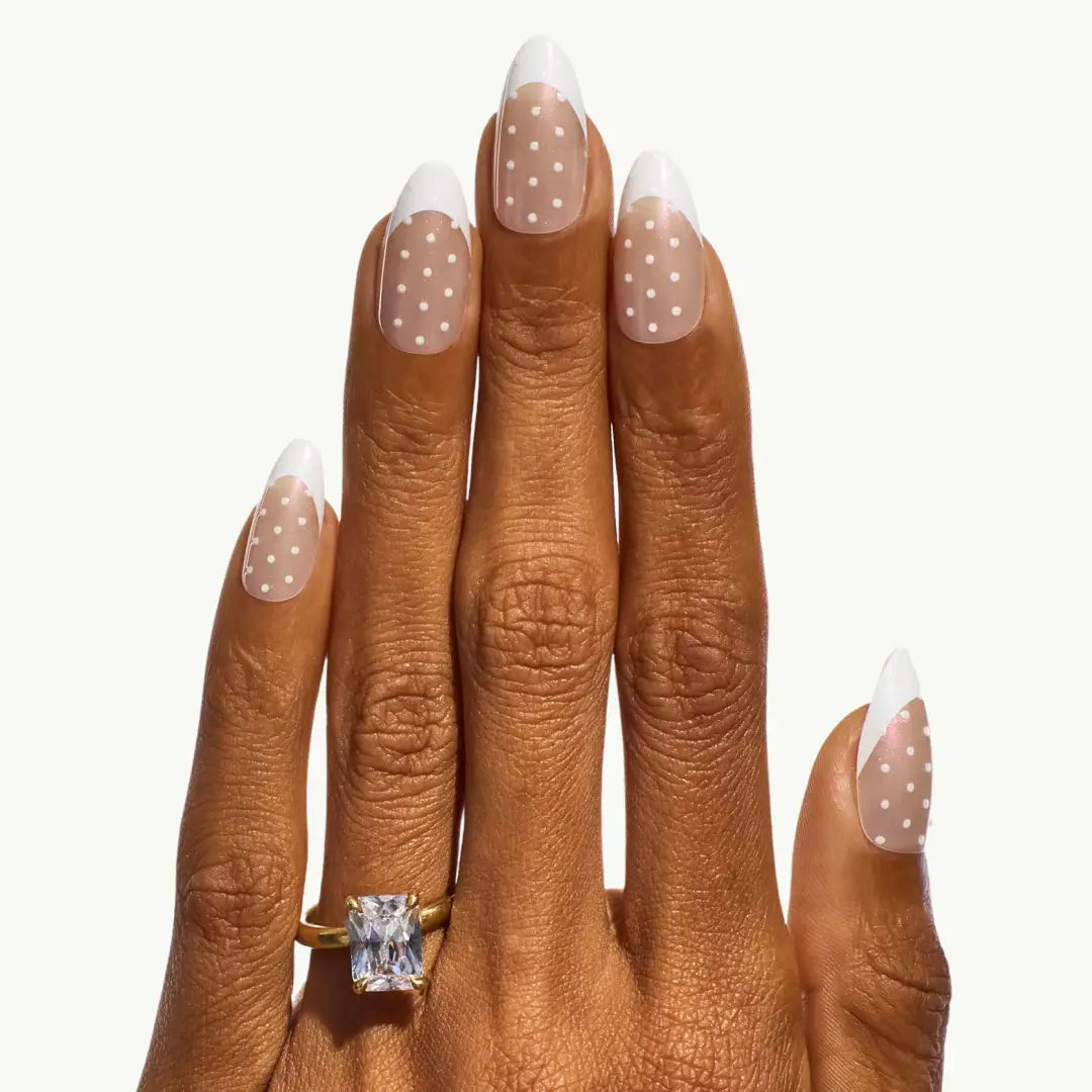 Hand wearing a gold ring with a diamond on a white background