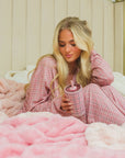 woman holding a plaid pink water bottle 