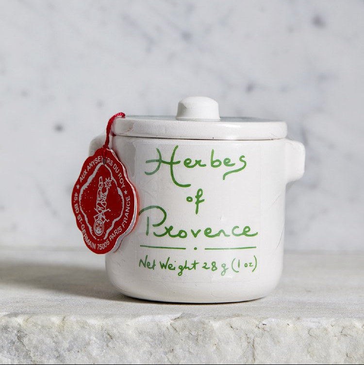 White ceramic container with 'Herbes of Provence' label on a marble surface