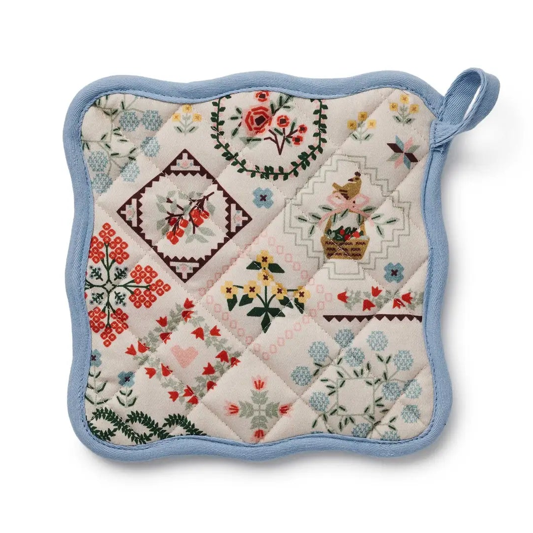 Quilted pot holder with floral and geometric patterns on a white background
