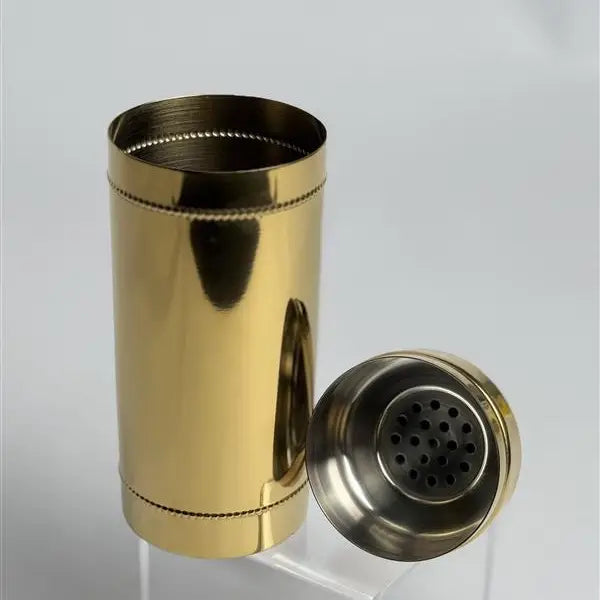 Gold and silver cocktail shaker on a light gray background