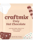 A single packet of Craftmix Cozy Hot Chocolate mix, with decorative illustrations of a hot chocolate cup, snowflakes, and holiday sprinkles. The packet reads 'Just Add Vodka, Water & Ice. Makes 1 Cocktail or Mocktail