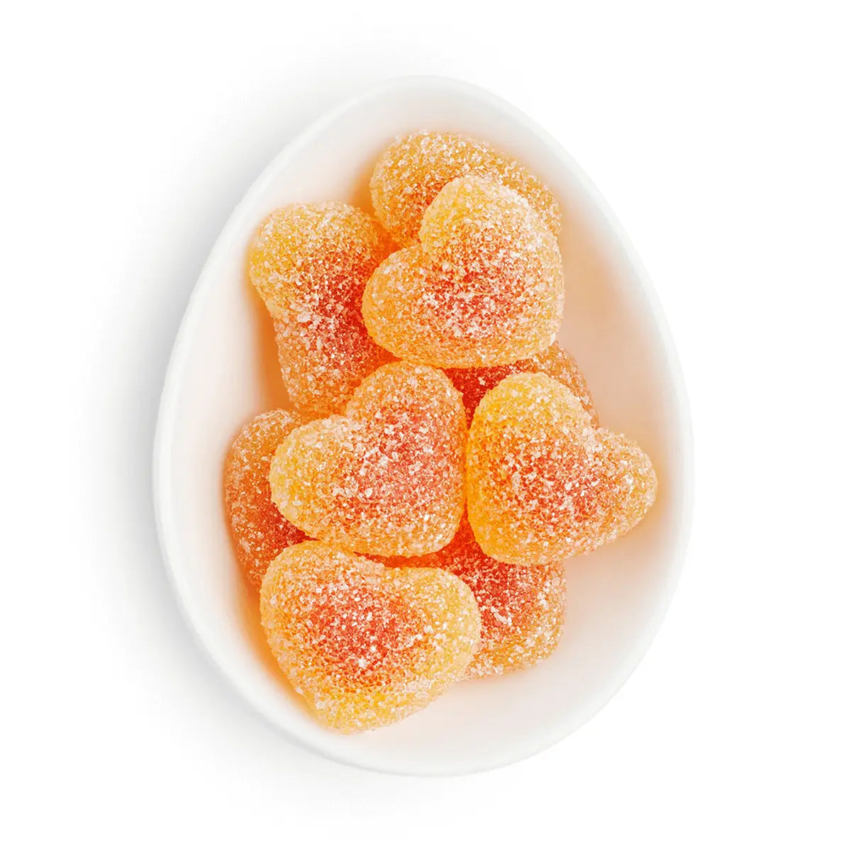 Heart-shaped gummy candies in a white bowl on a white background