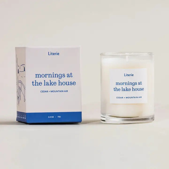 Lit candle and packaging of 'Mornings at the Lake House' by Literie on a light background