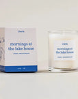 Lit candle and packaging of 'Mornings at the Lake House' by Literie on a light background