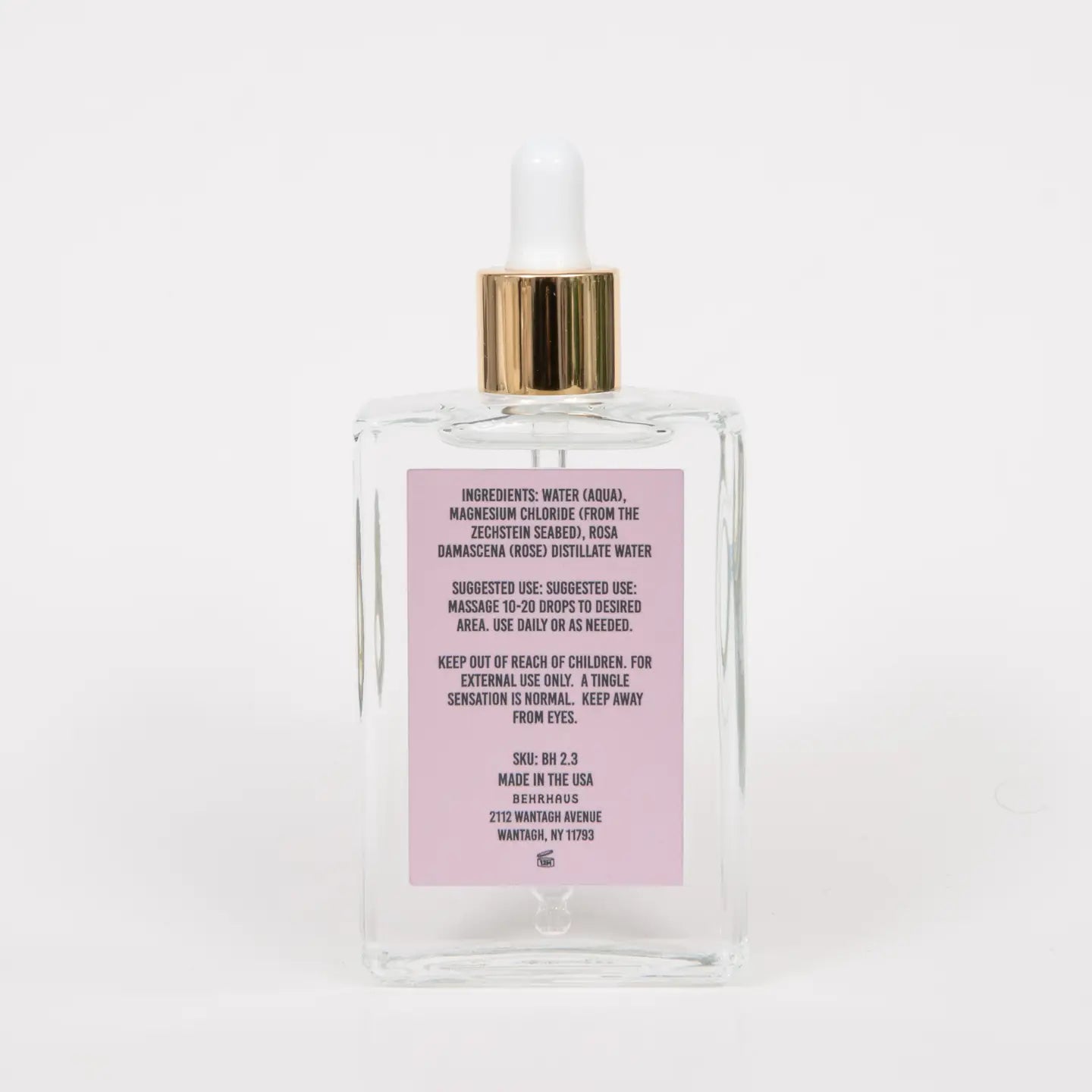 Perfume bottle with a gold cap and pink label on a white background