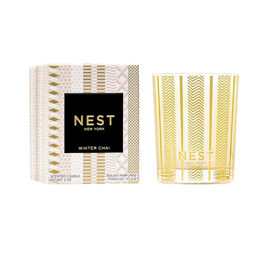 box with pink and gold design and a black label with gold writing that says "nest new york" and a gold candle 