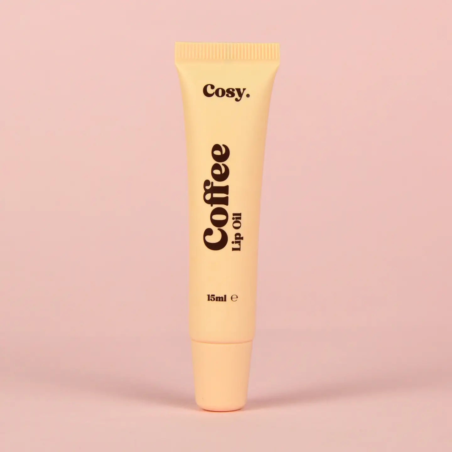 Cosy Coffee Lip Oil tube on a pink background