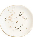 White ceramic plate with gold and bronze speckles on a white background