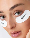 Close-up of a person wearing eye patches with 'WIFEY' text on a neutral background