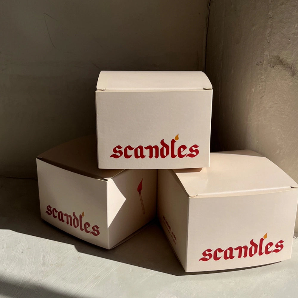 Three 'scandles' boxes stacked against a neutral wall.