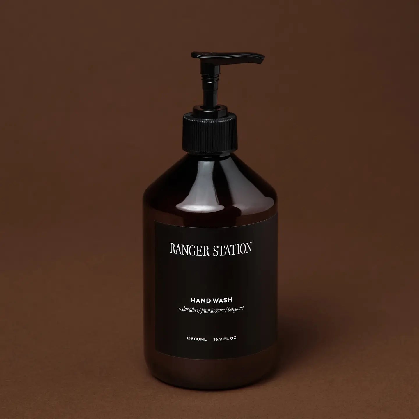 Black hand wash bottle with pump on a brown background