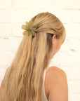 Girl with blonde hair wearing Green Daisy Claw Clip