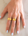 Hand with Gold Croissant Ring and Gold Cancer Ring