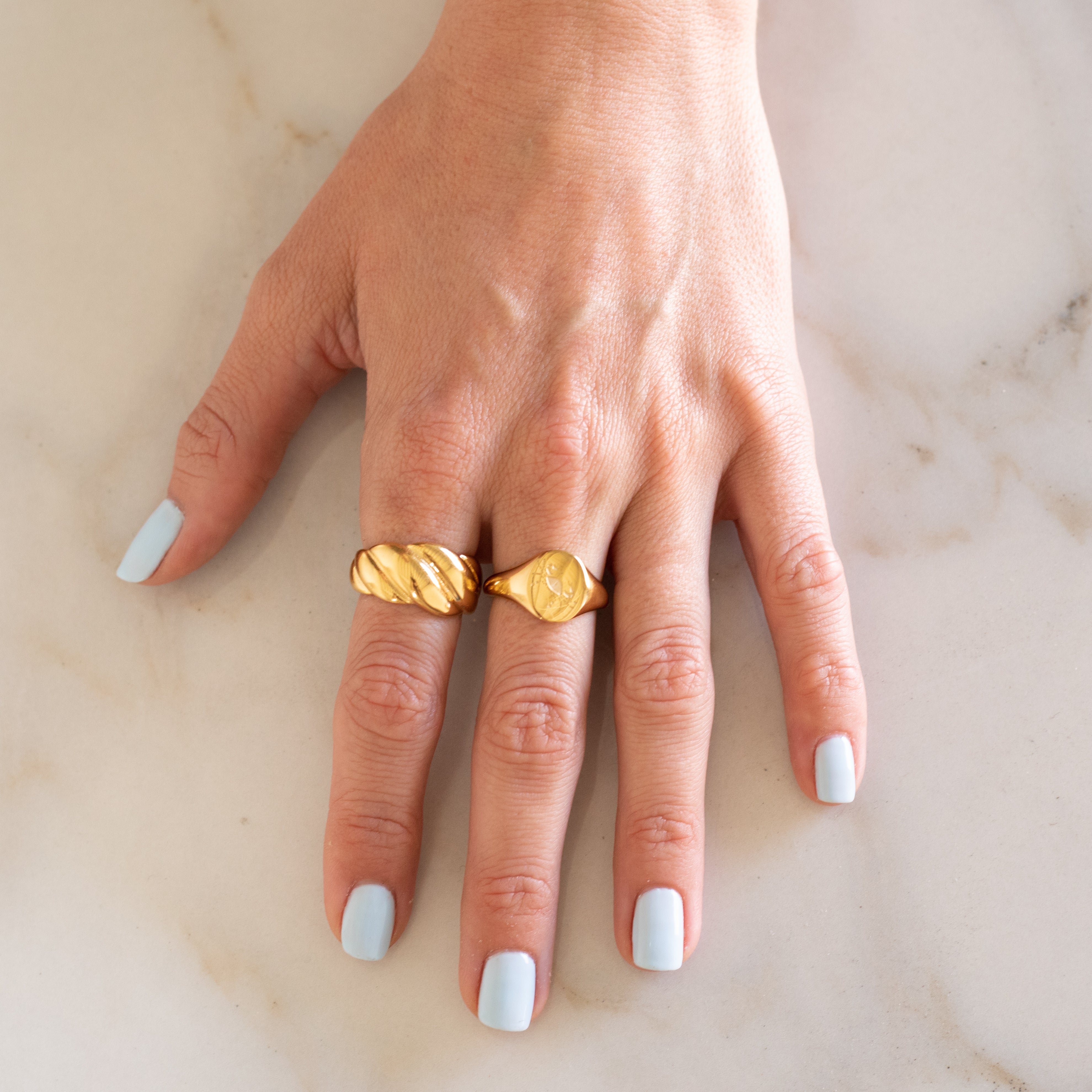 Hand wearing Gold Croissant Ring and Gold Cancer ring
