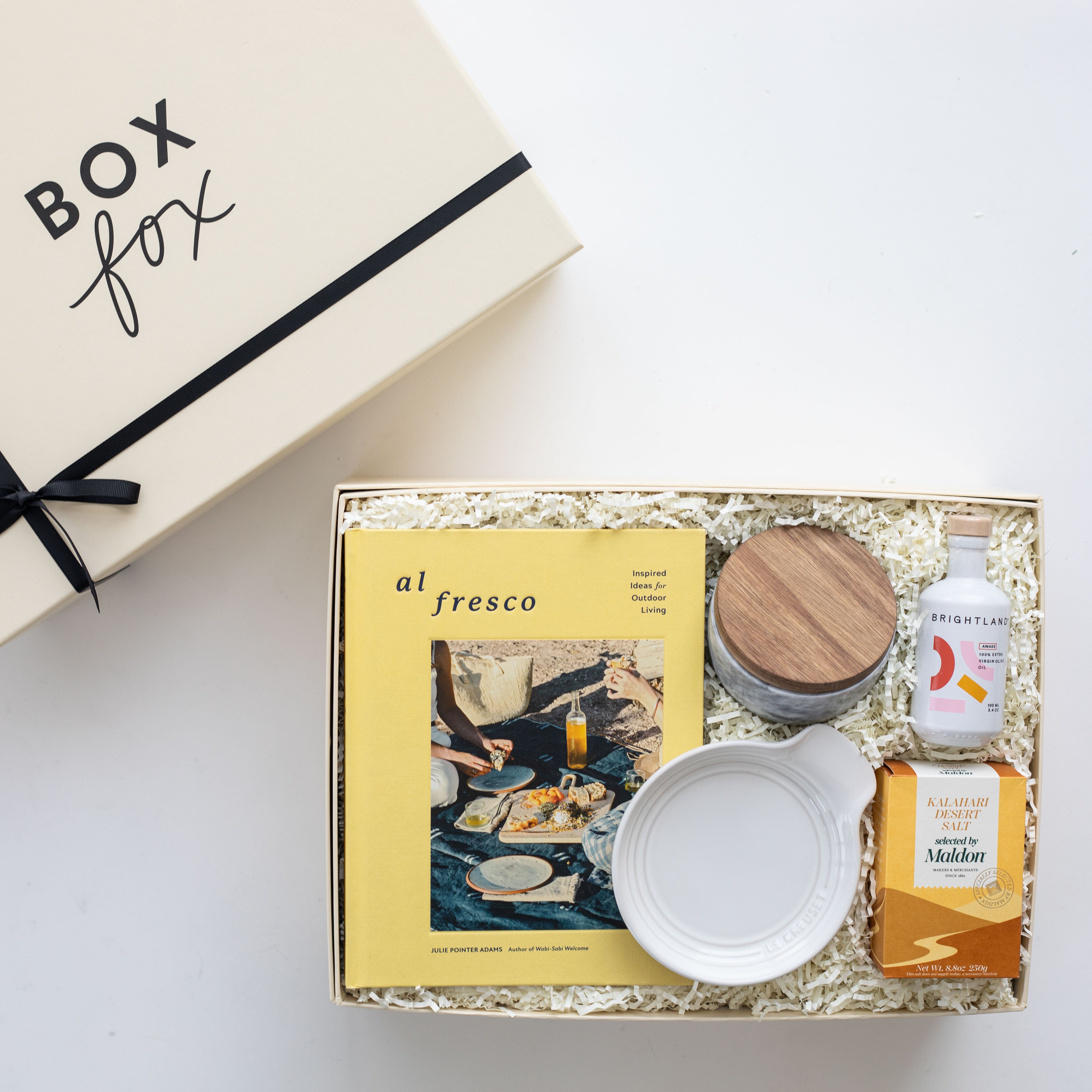 Gift box with 'Box Fox' branding, featuring a magazine, bowls, and a bottle on a white background.