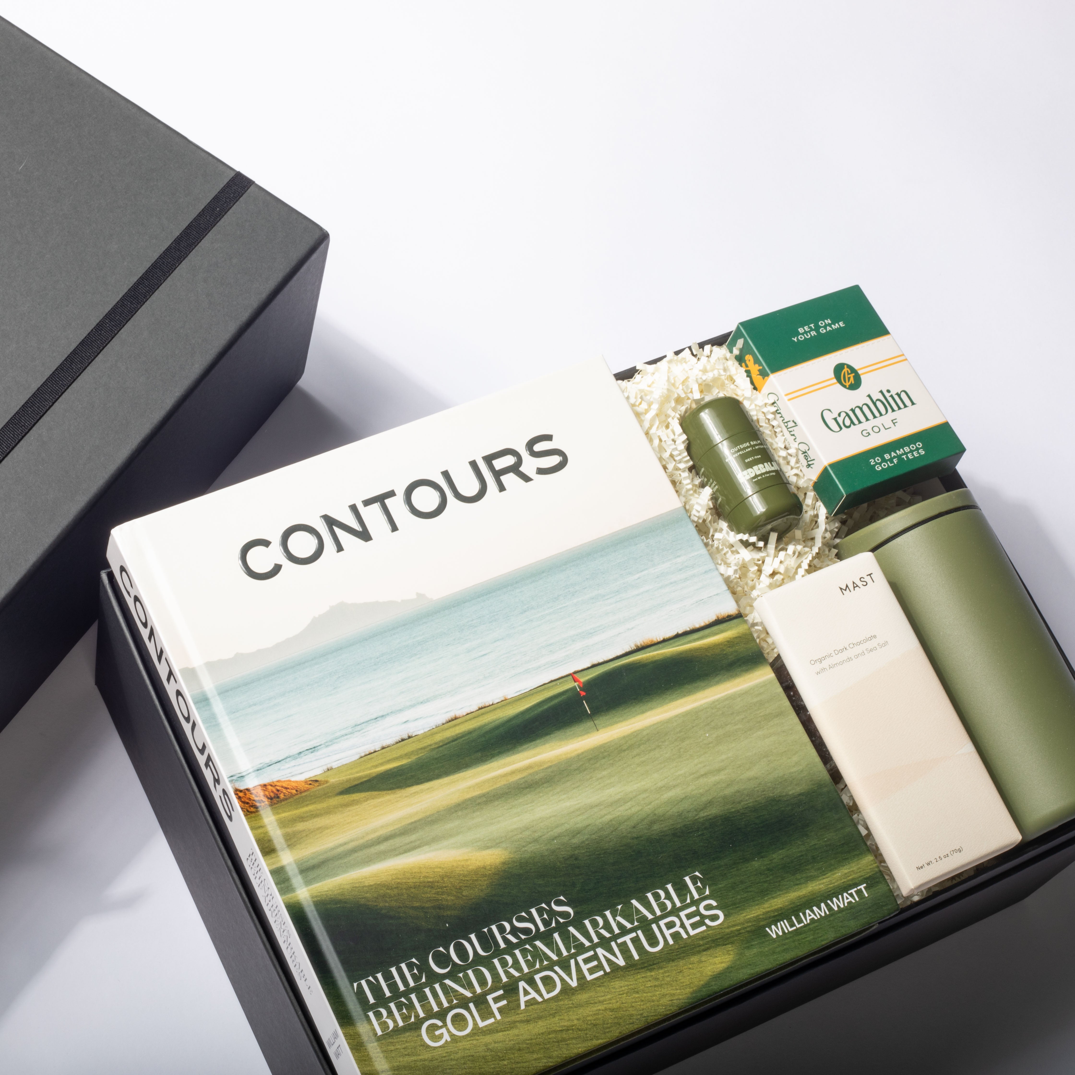 Golf-themed book titled 'Contours' with a green water bottle and other items on a white surface.
